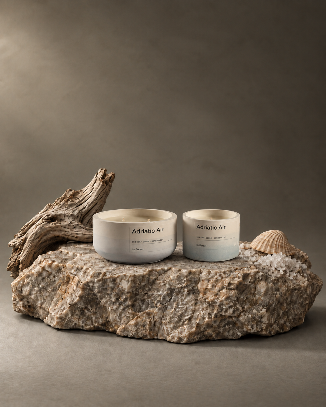 Two Adriatic Air candles with driftwood on a stone pedestal