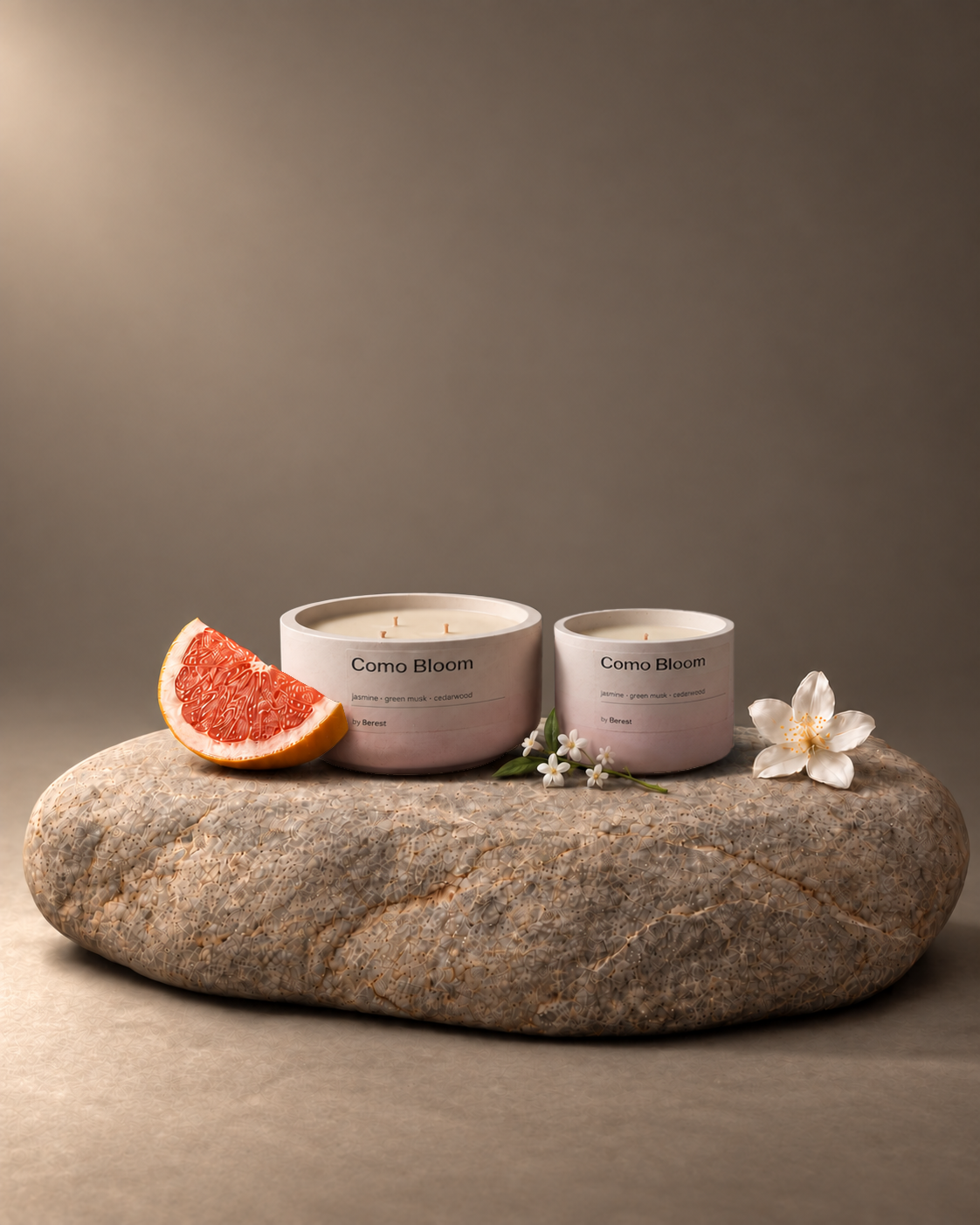 Como Bloom candles with flowers and grapefruit on limestone